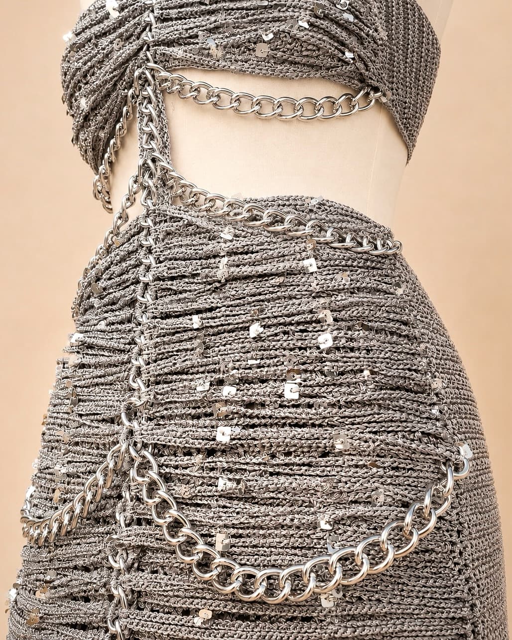 Vestido de crochê prateado com brilho e correntes metálicas estilo festa